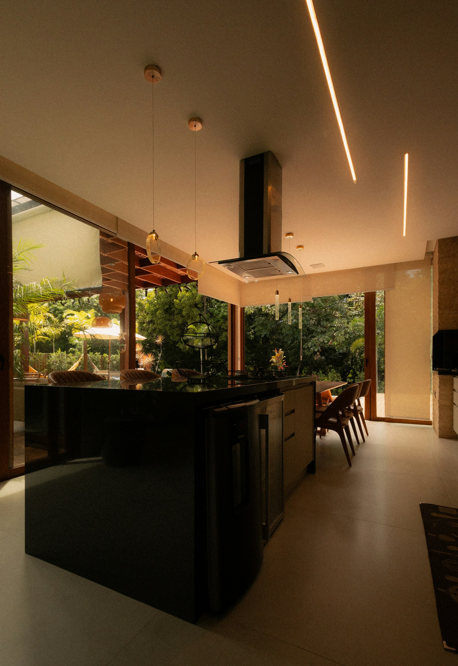 Modern kitchen at dusk with linear cove lighting and pendant fixtures